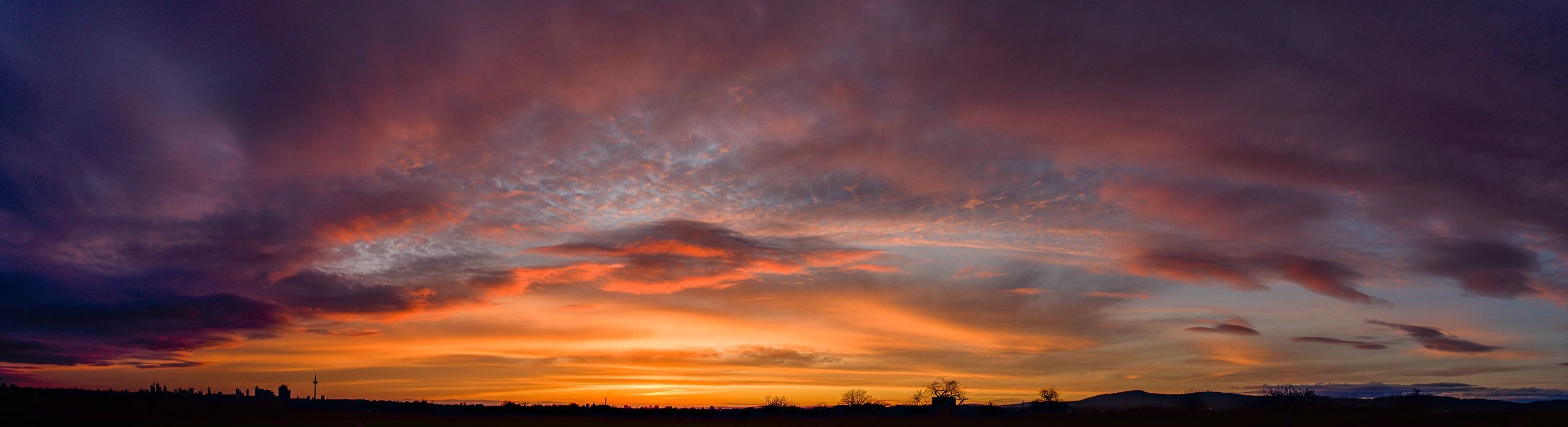 Orange sunset clouds over a wide western horizon