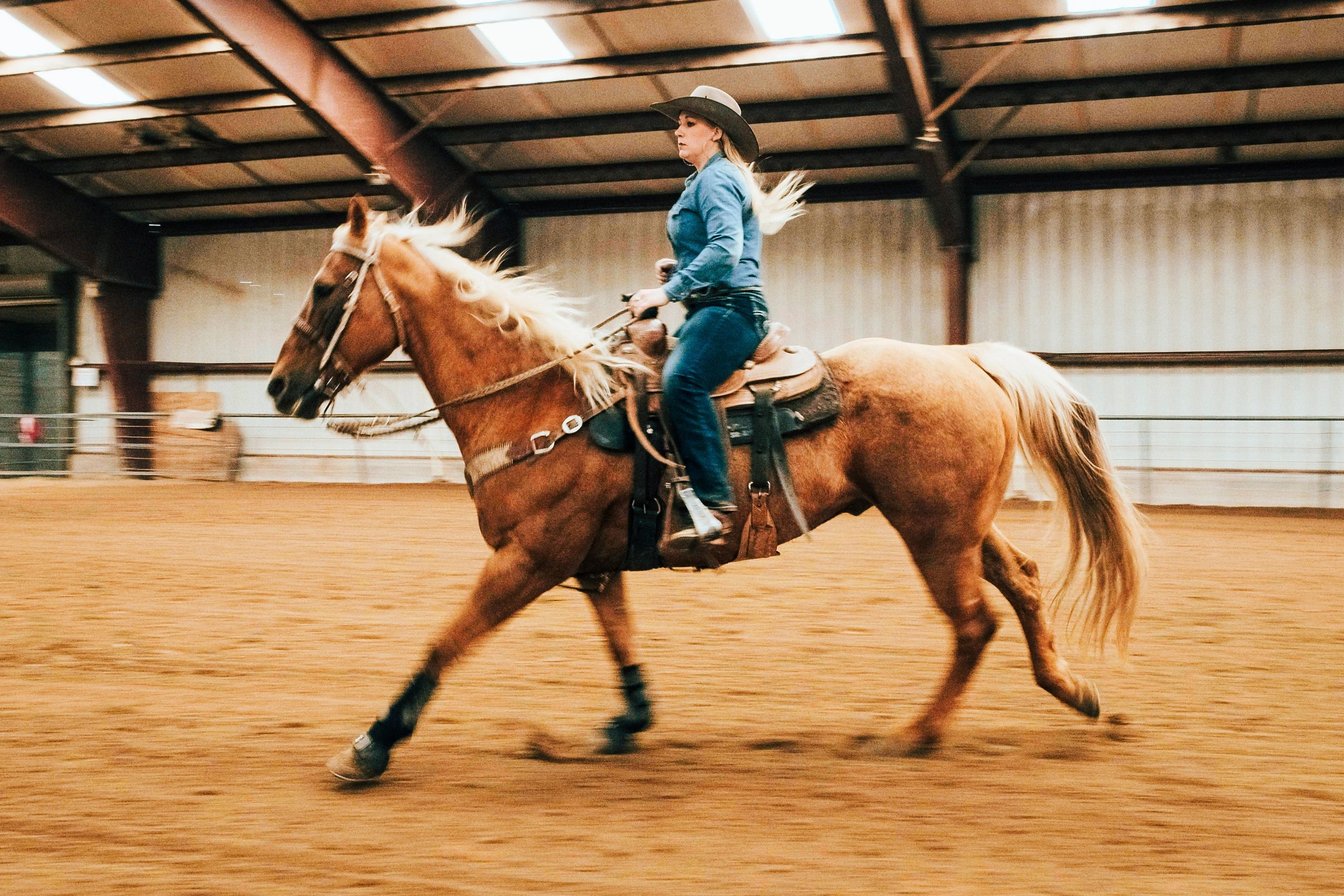 Cowgirl practicing in an indoor riding arena