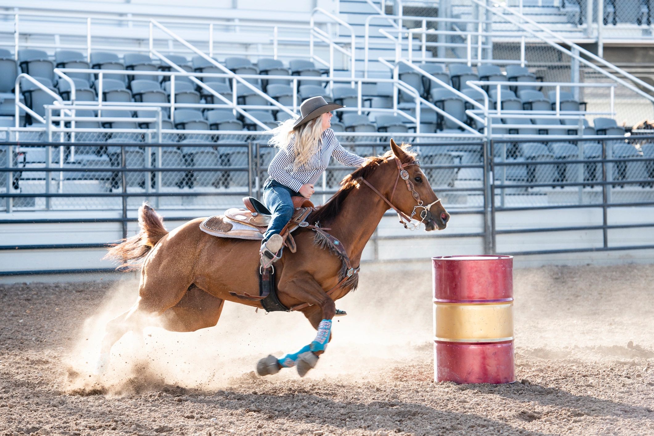 Barrel racer turning a barrel in a rodeo arena
